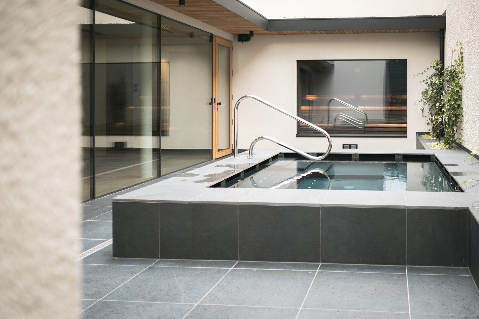 Outdoor whirlpool with a view of the sauna and relaxation room - Gisse Zwölf