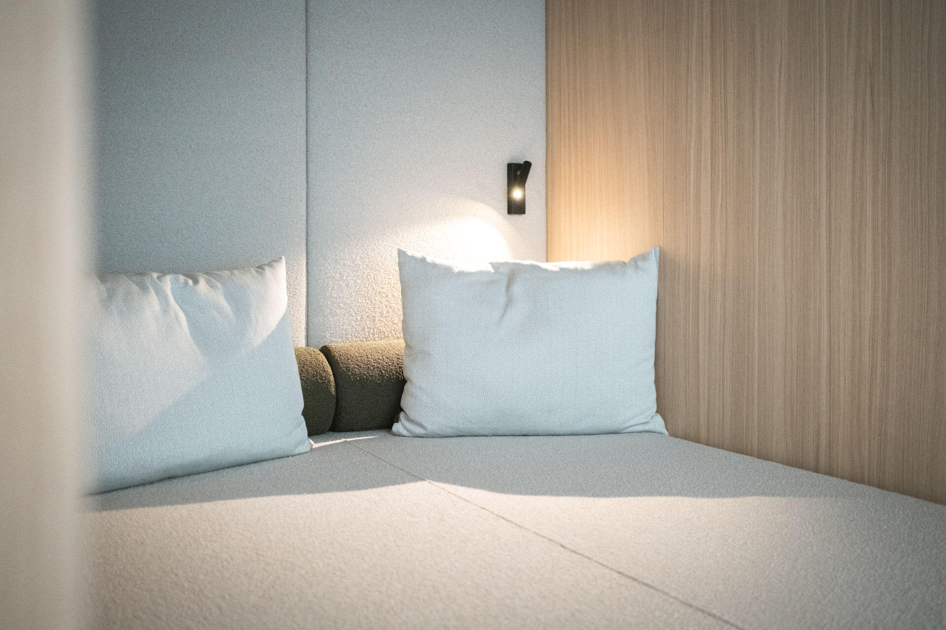 Sofa with wall lighting and white cushions - Gisse Zwölf