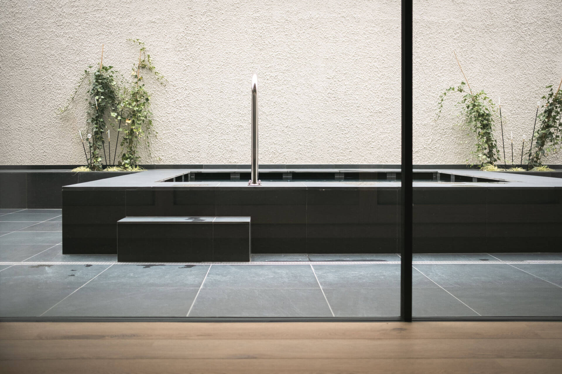 Relaxation room with a view of the outdoor whirlpool and plants - Gisse Zwölf