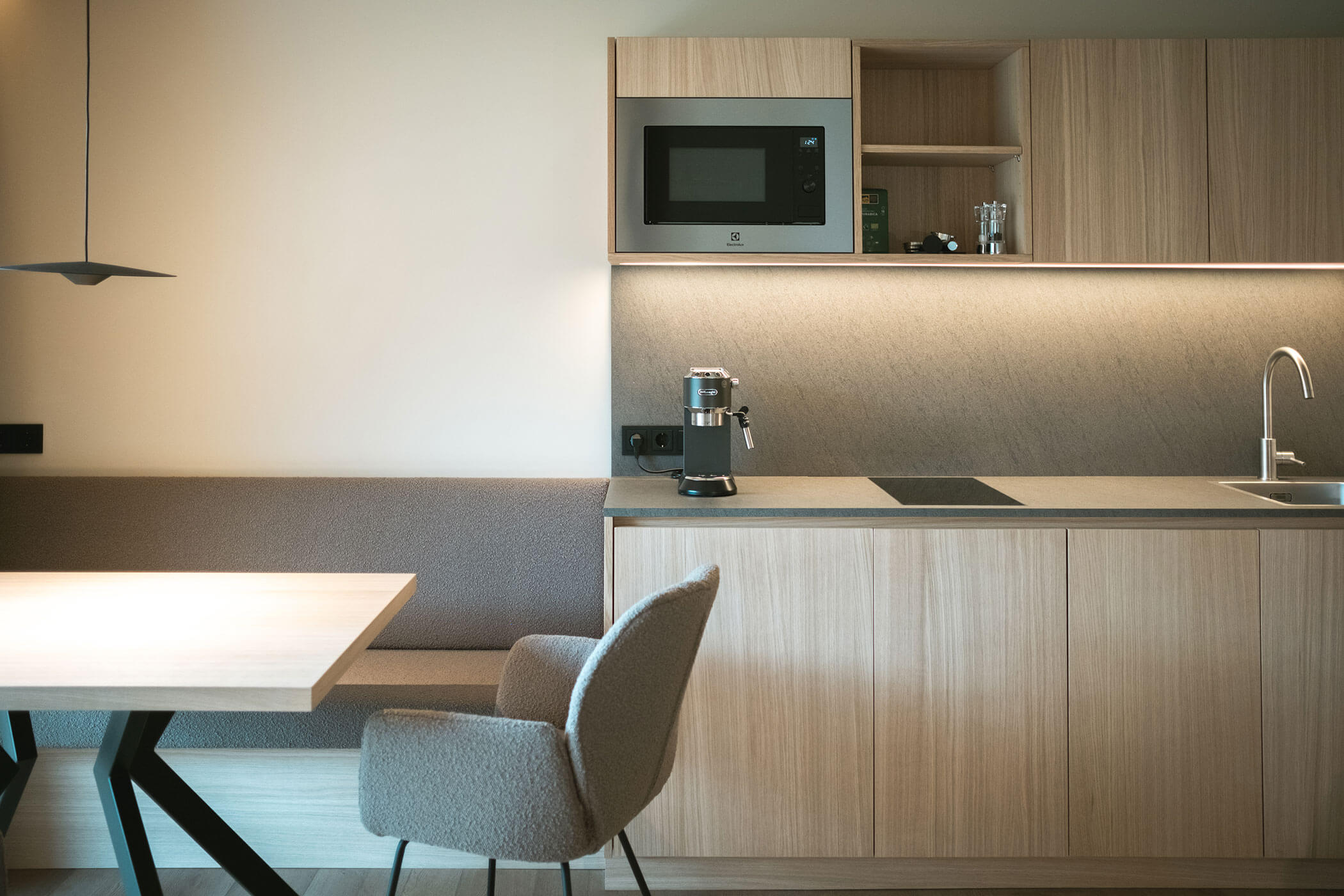 Kitchenette with microwave and coffee maker, a chair next to it - Gisse Zwölf