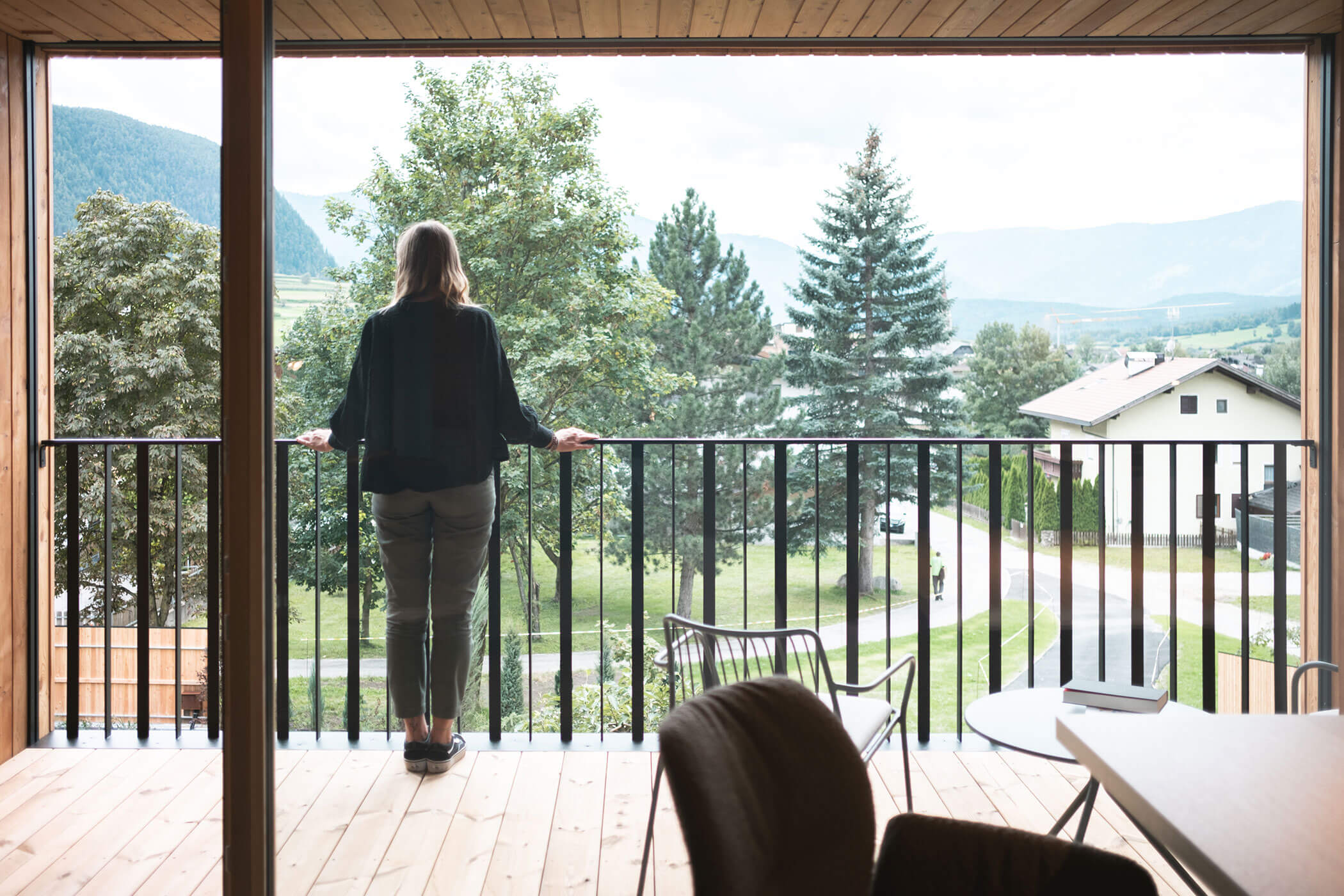 Woman standing on the balcony and enjoying the view - Gisse Zwölf
