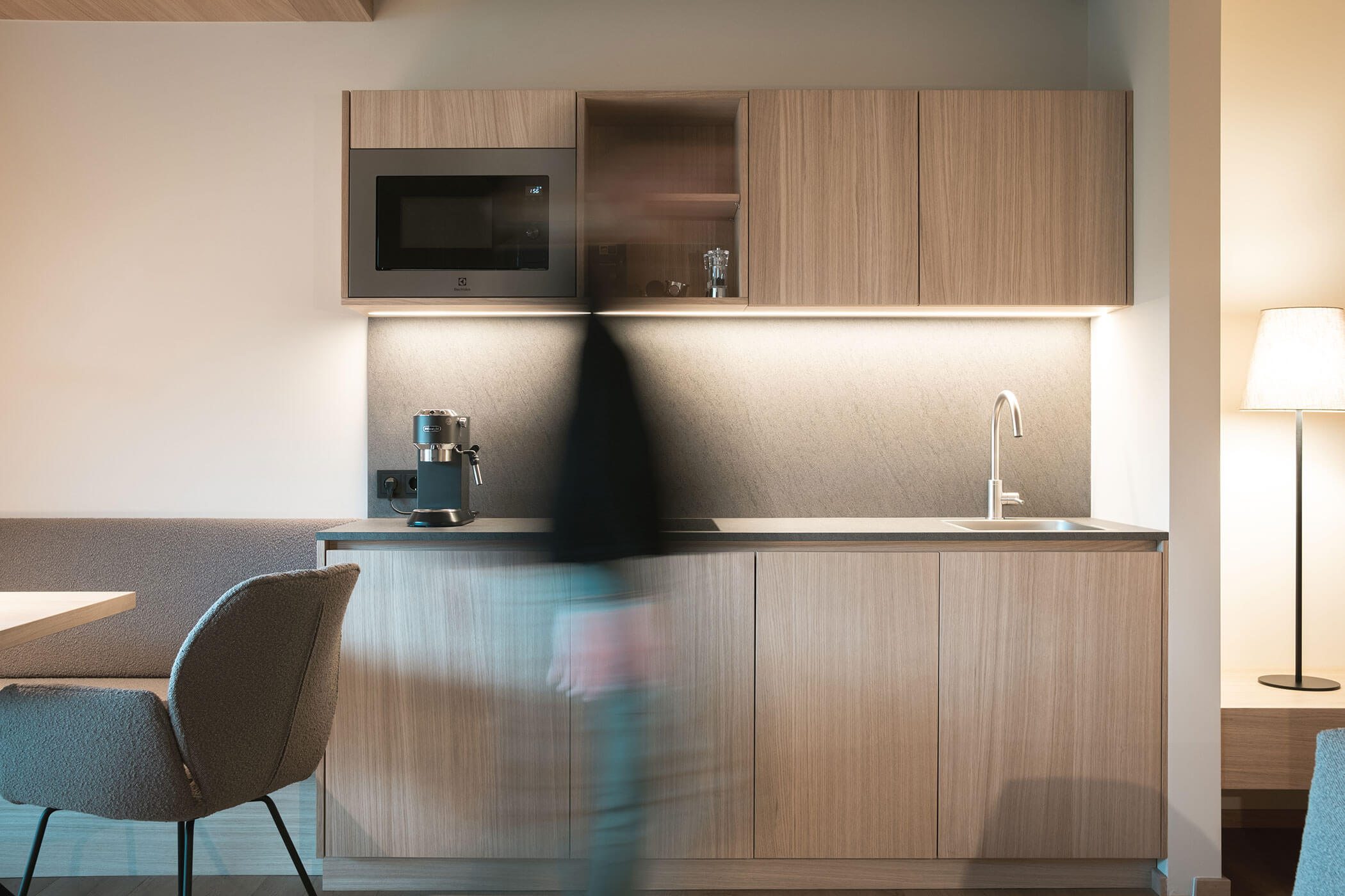Kitchenette with microwave and coffee maker, a chair next to it - Gisse Zwölf