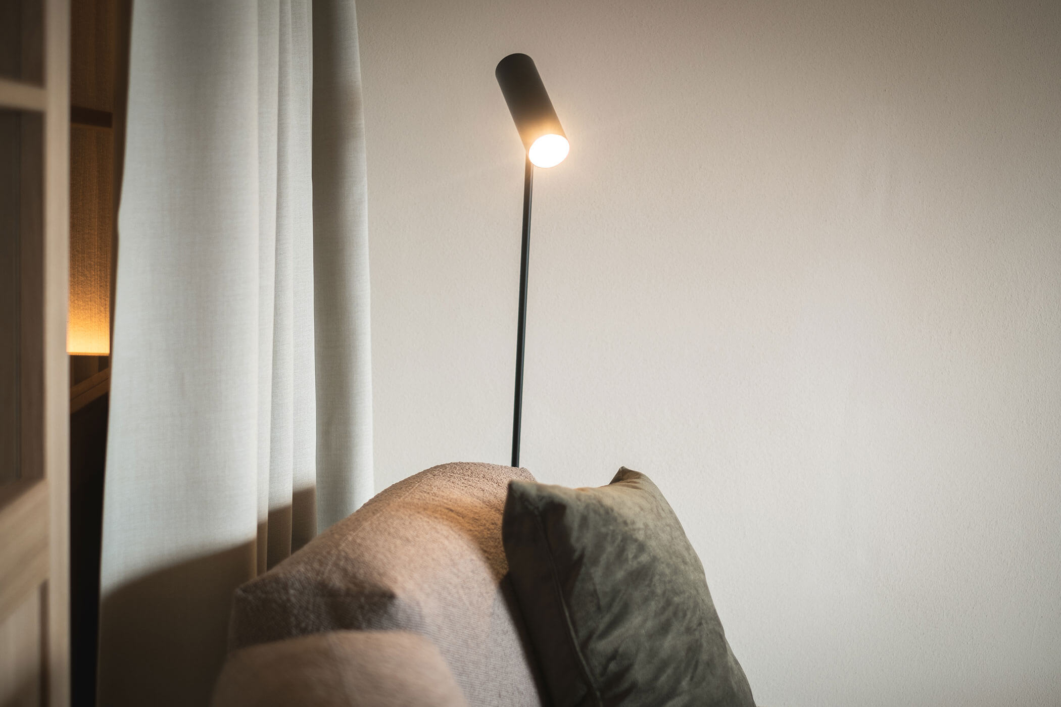 Black floor lamp lights up the sofa - Gisse Zwölf