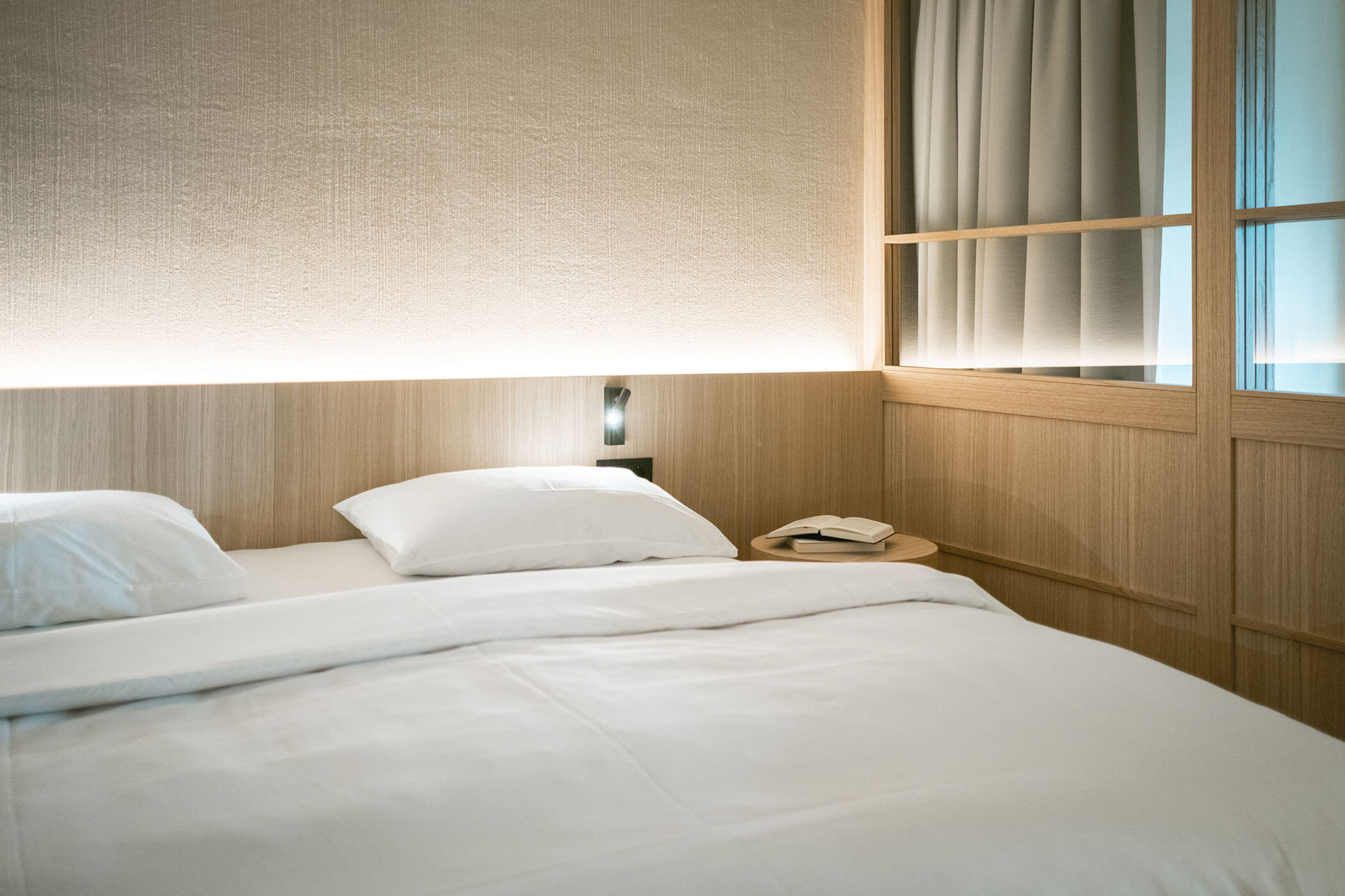 Illuminated bedside table with two books on the bedside table - Gisse Zwölf